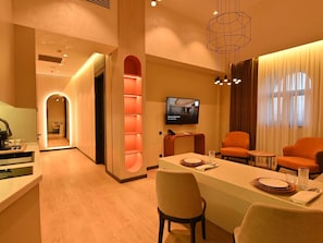 Una habitación de hotel moderna con comedor, televisión y vista a la ciudad.