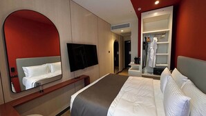 A hotel room with a bed, a TV, a mirror, and a wardrobe. - Mercure Tashkent North (Tashkent)
