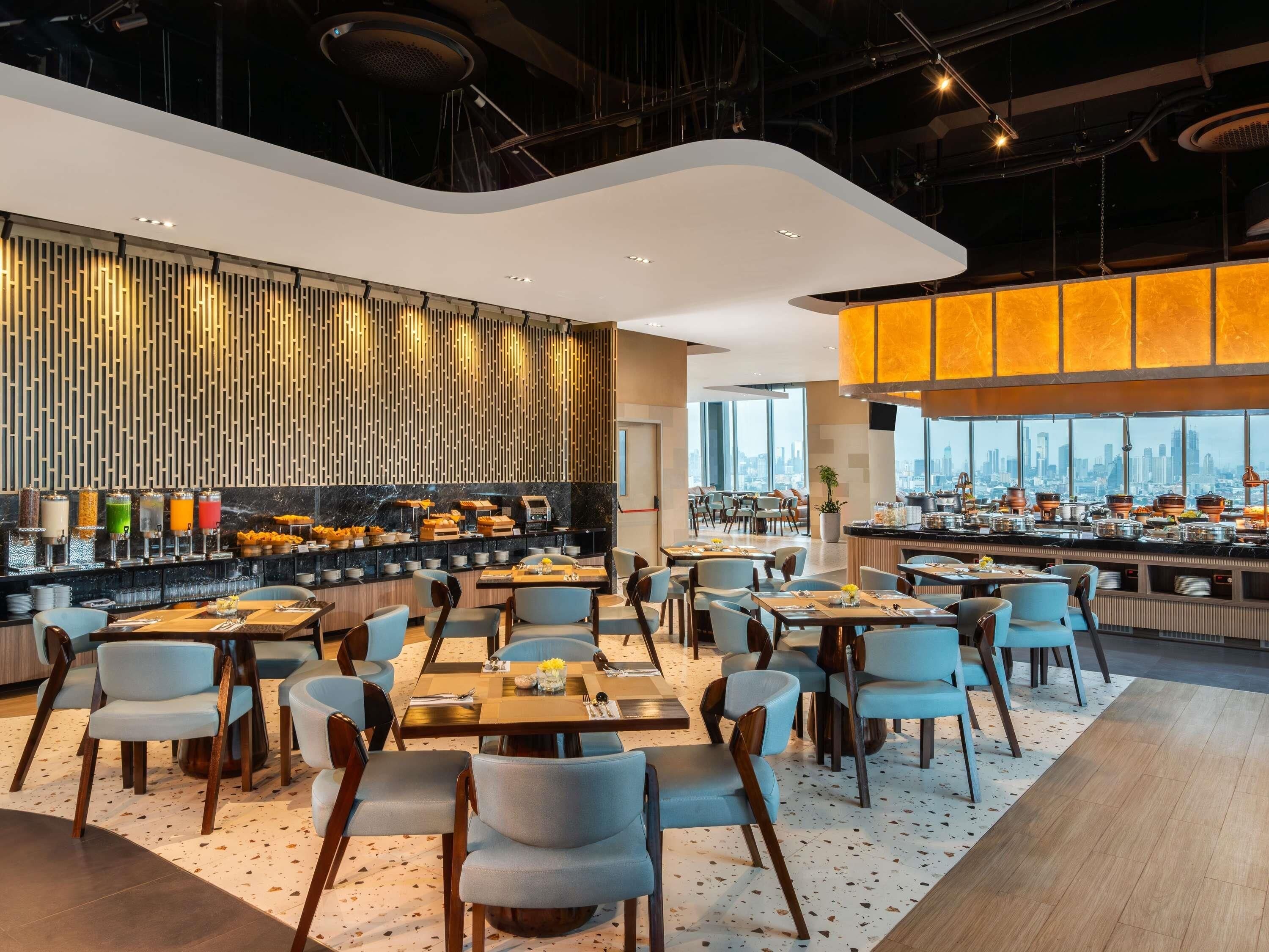 Un restaurante moderno con barra, asientos y vistas a la ciudad.
