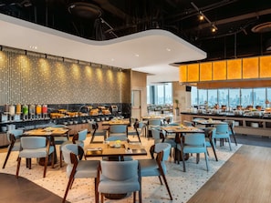 Un restaurante moderno con barra, asientos y vistas a la ciudad.