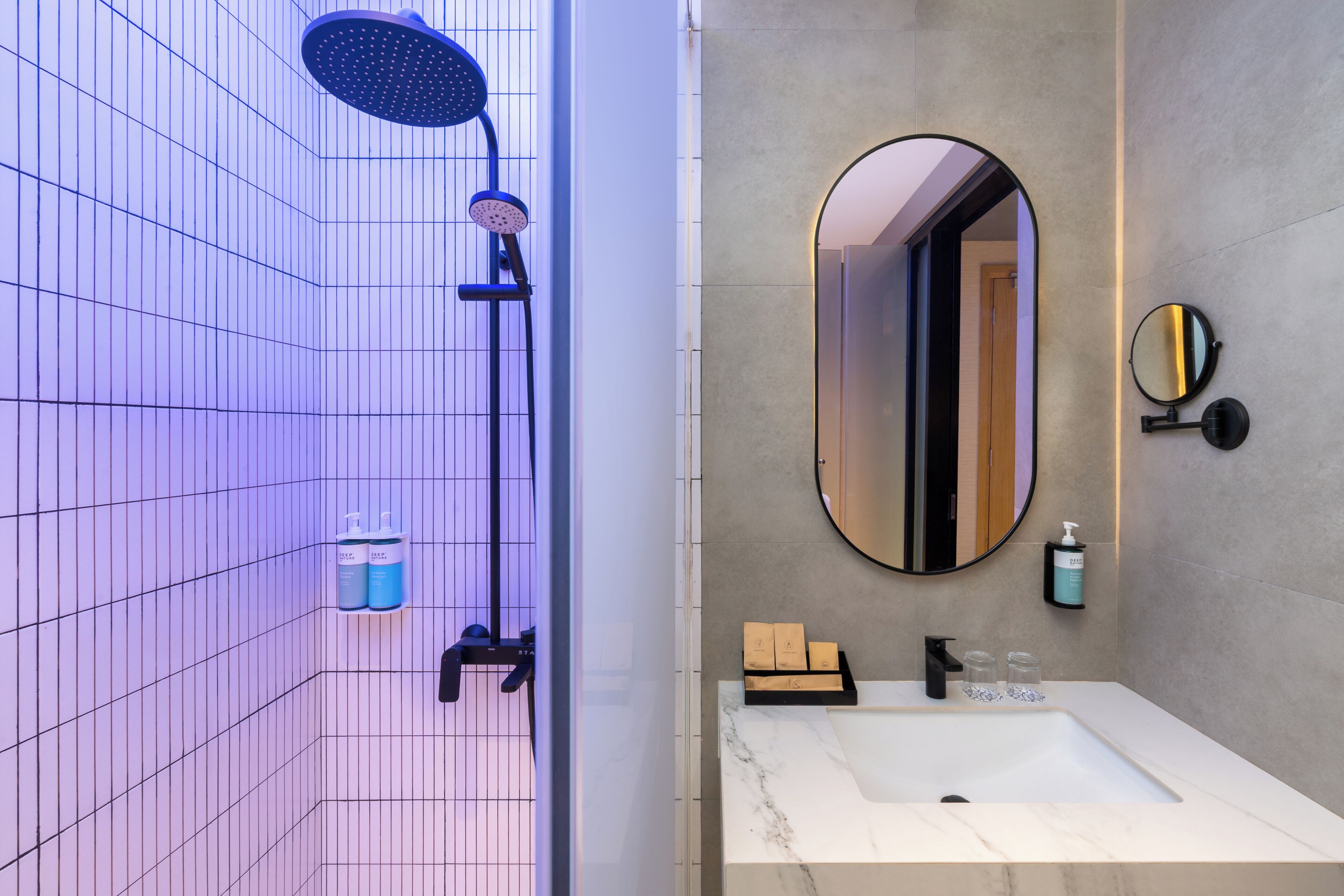 Een moderne badkamer met een douche, een wastafel en een spiegel.