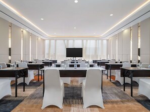 A conference room with a large table, chairs, a flat-screen TV, and large windows. - Novotel Jakarta Pulomas (Jakarta)