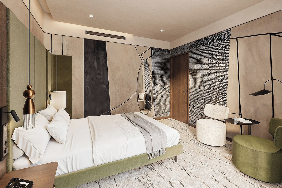 A modern bedroom with a bed, bedside table, lamp, and a chair.