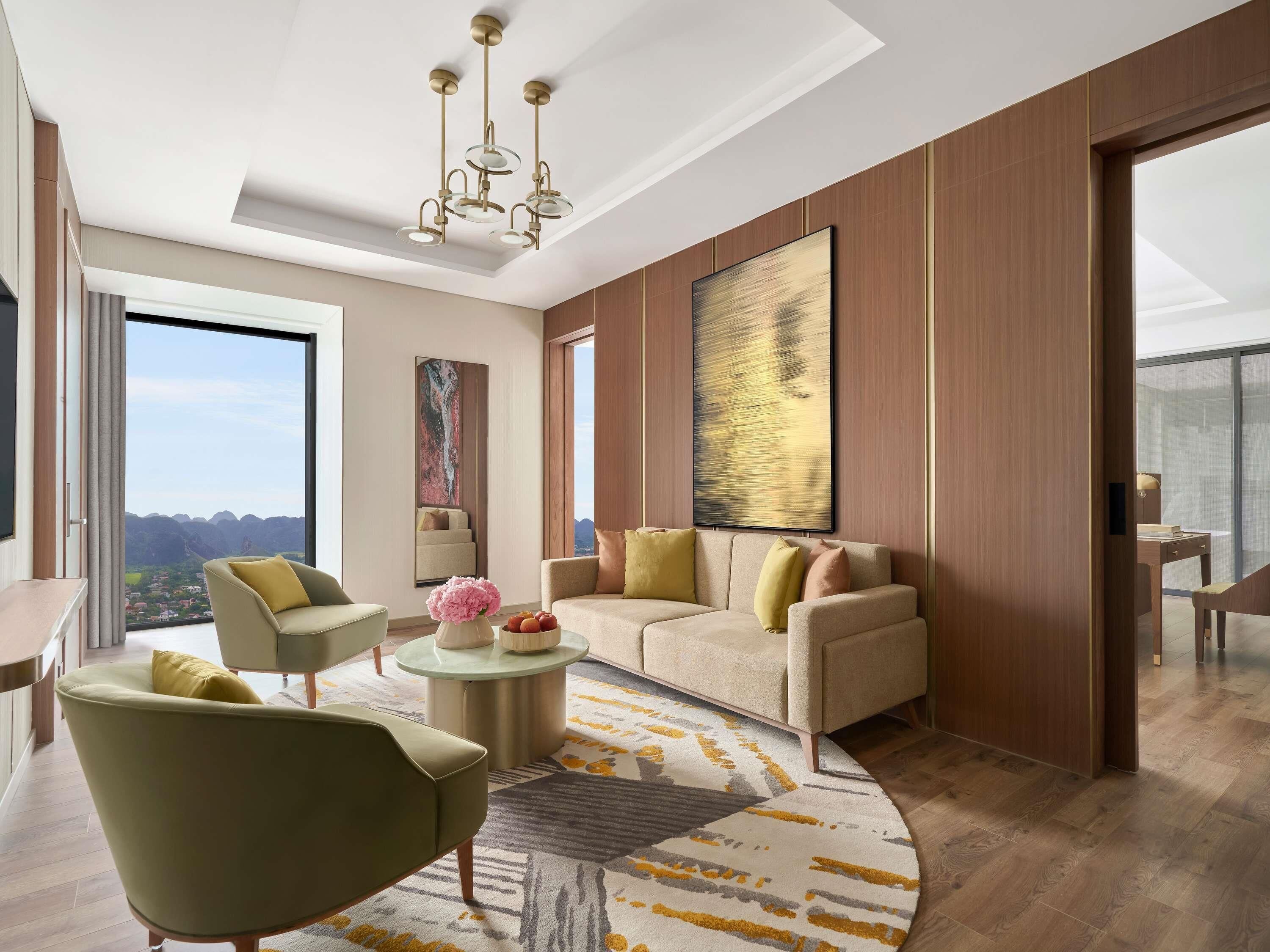 Un salon moderne avec un canapé, des fauteuils, une table basse et un grand tableau abstrait accroché au mur.