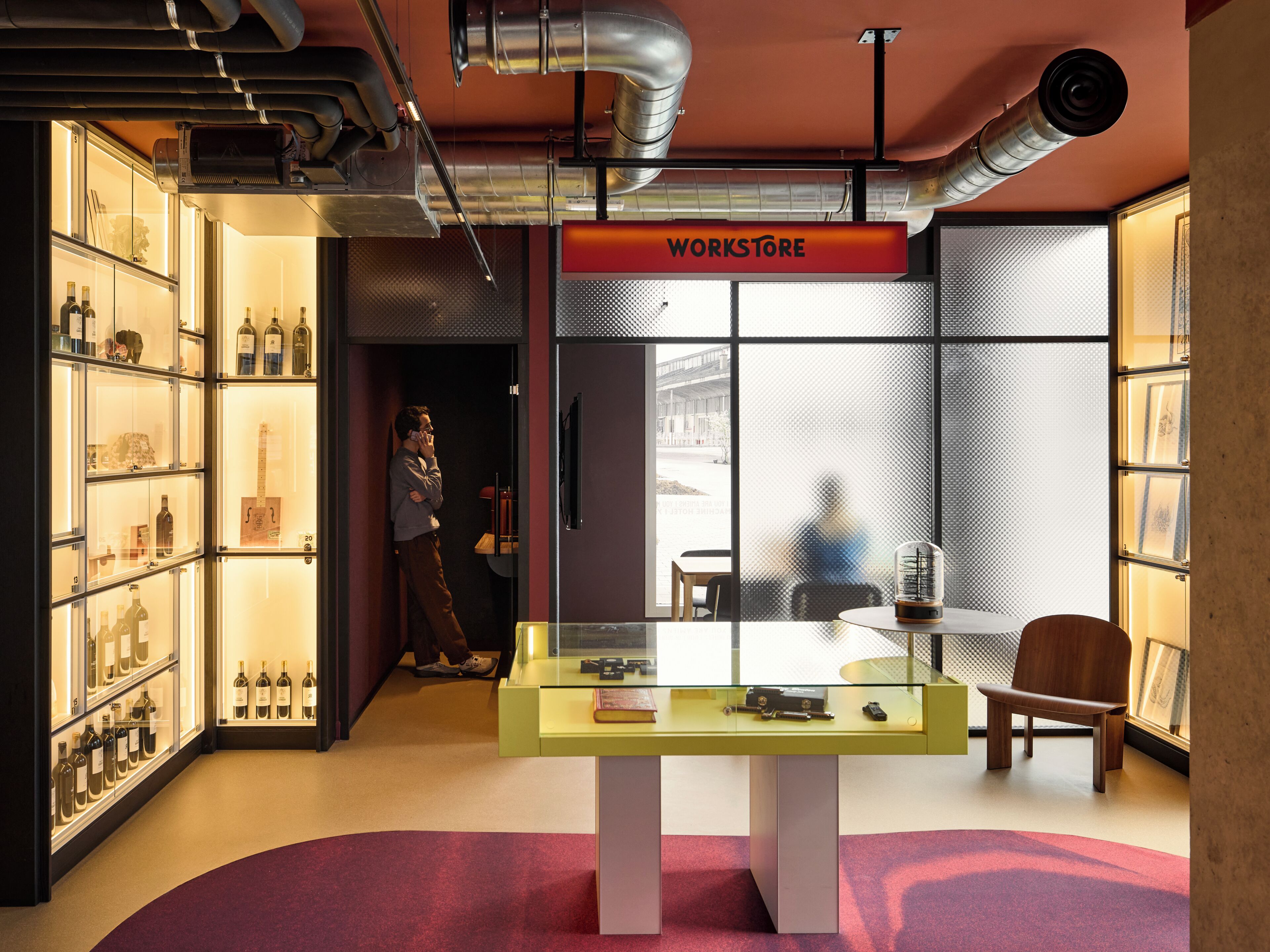 A workroom with a glass table, shelves with bottles, and a sign reading 'WORKSTORE'.