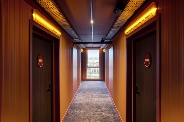 A hallway with wooden walls and doors, each marked with a number. - You Hotel Amiens - Handwritten Collection (Amiens)