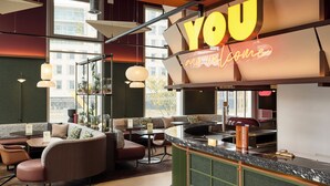 A modern interior with a bar area, seating, and large windows. - You Hotel Amiens - Handwritten Collection (Amiens)