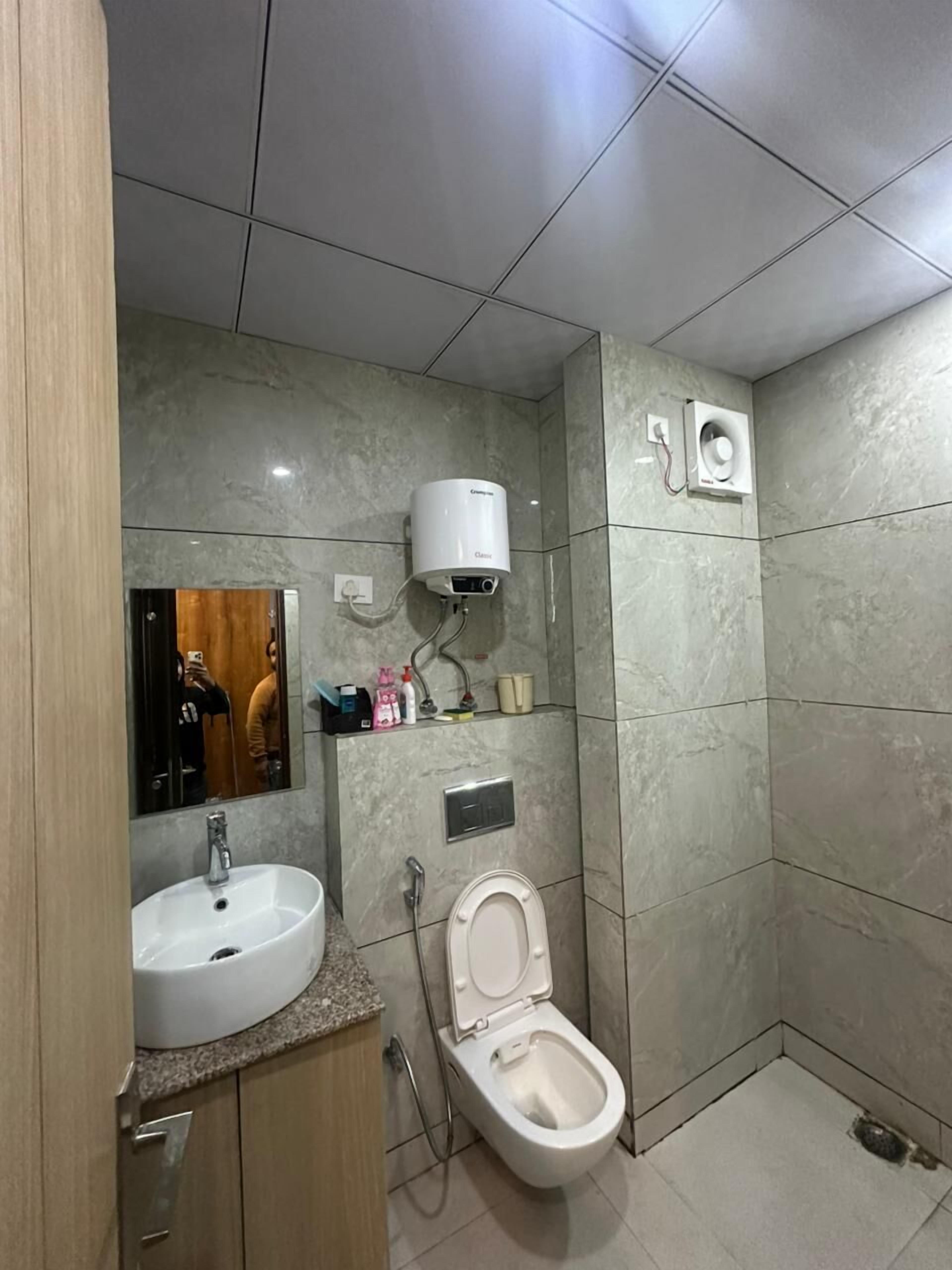 A modern bathroom with a sink, toilet, and a shower area.