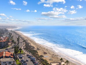 A coastal road with parked cars, a beach, and ocean views. - Carlsbad Coastal Retreat 1BR (Carlsbad)