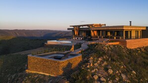 A modern house with a pool, outdoor seating, and a view of the mountains. - Mantis Hiddn In Addo (Gqebergha)