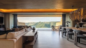 A modern living room with a large window overlooking a mountainous landscape. - Mantis Hiddn In Addo (Gqebergha)
