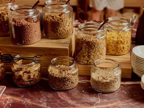 Verschiedene Gläser mit Granola auf einer Holzoberfläche.