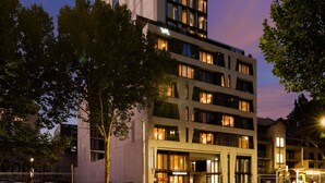 A multi-story hotel with a modern architectural design, featuring a prominent vertical element and illuminated windows. - Mercure Melbourne La Trobe Street (West Melbourne)