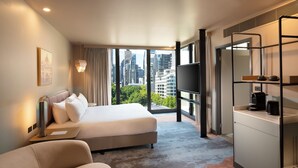 A modern hotel room with a large bed, a desk, a TV, and a city view. - Mercure Melbourne La Trobe Street (West Melbourne)