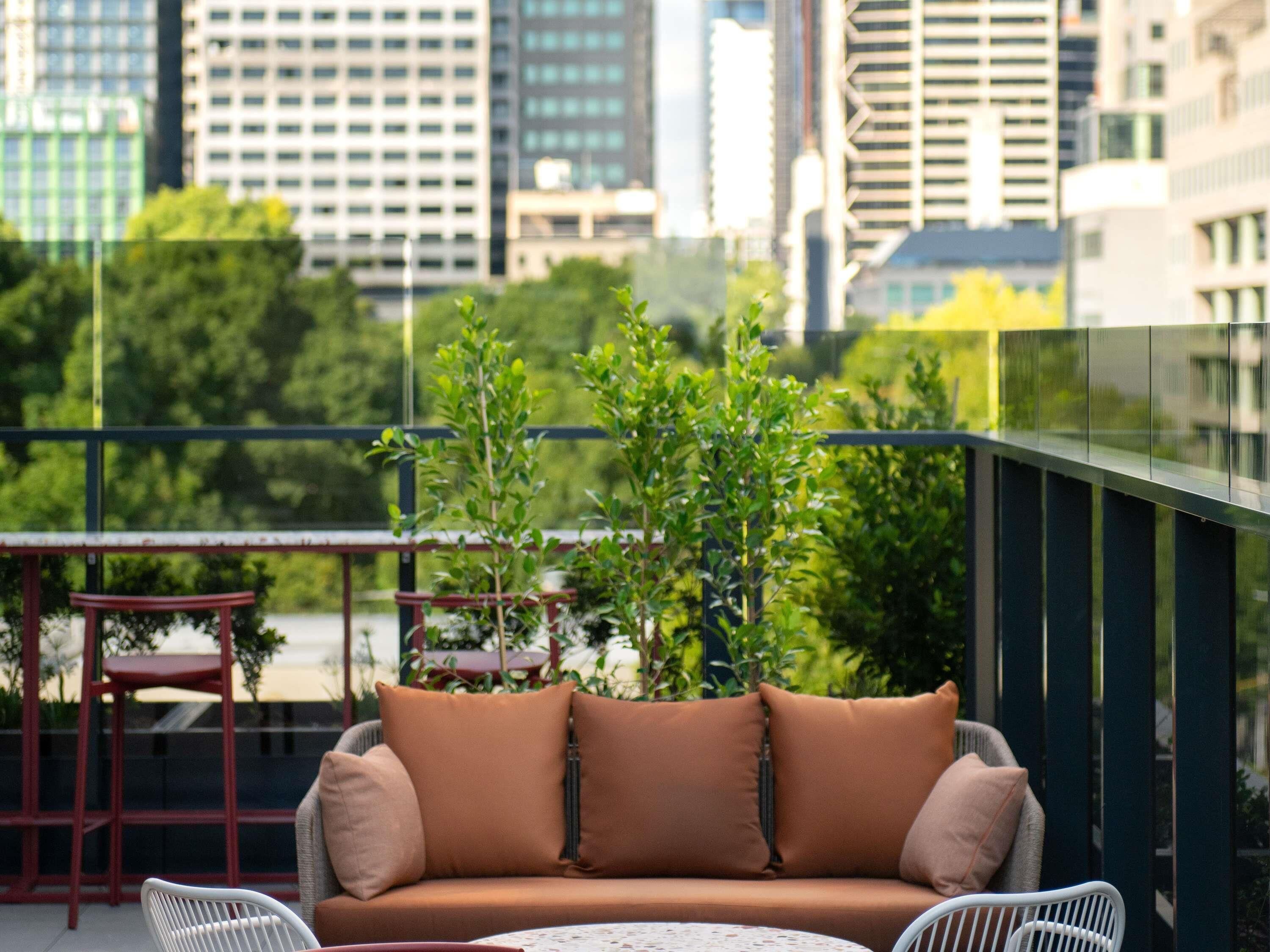 A balcony with a sofa, a small table, and a chair.