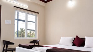 Hotellihuone, jossa on sänky, työpöytä ja tuoli.