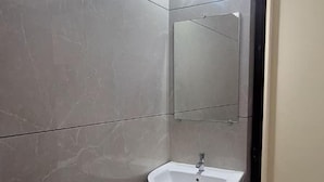 A bathroom with a pedestal sink, a mirror, and a tiled floor. - Highway Heaven (Bhatkal)