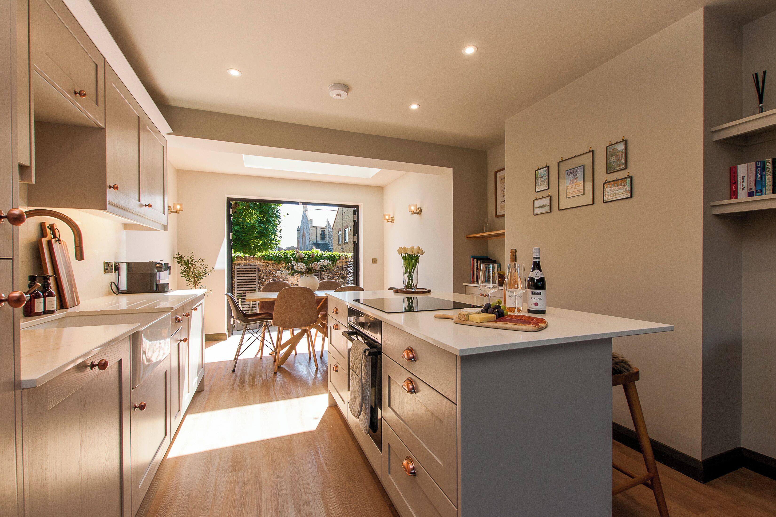 Una cucina moderna con isola centrale, elettrodomestici integrati e zona pranzo illuminata dalla luce naturale.