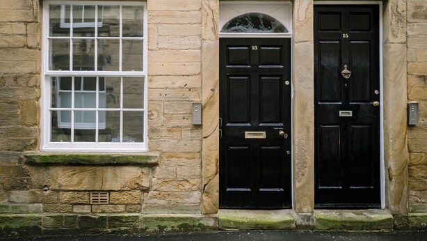 A stone building with a black door labeled '15' and a window with a grid pattern. - Sun St Apartment 4 (Lancaster)