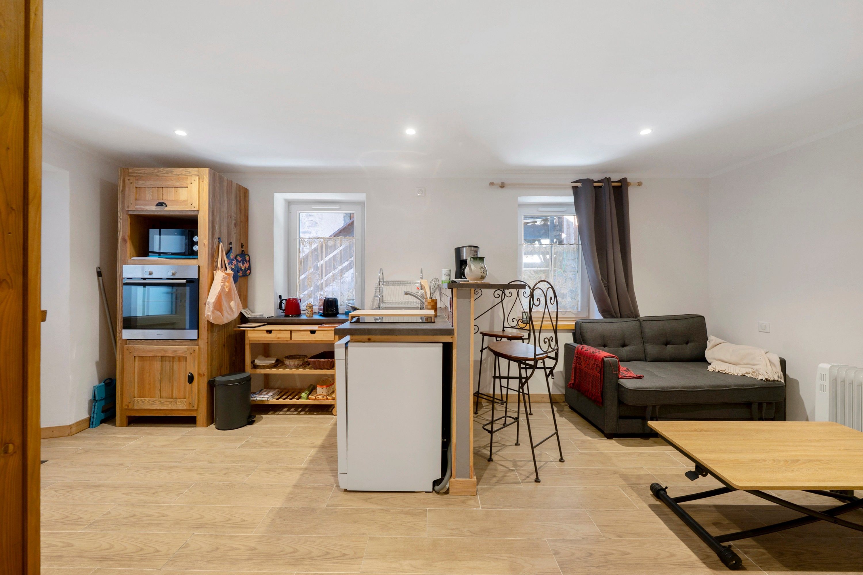 Een compacte woonruimte met een kitchenette, een eethoek en een zithoek.