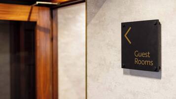 A sign indicating guest rooms with a directional arrow.