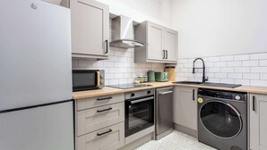 A compact kitchen with a built-in oven, microwave, and dishwasher. - The Annick Suite No1 - Donnini Apartments (Irvine)