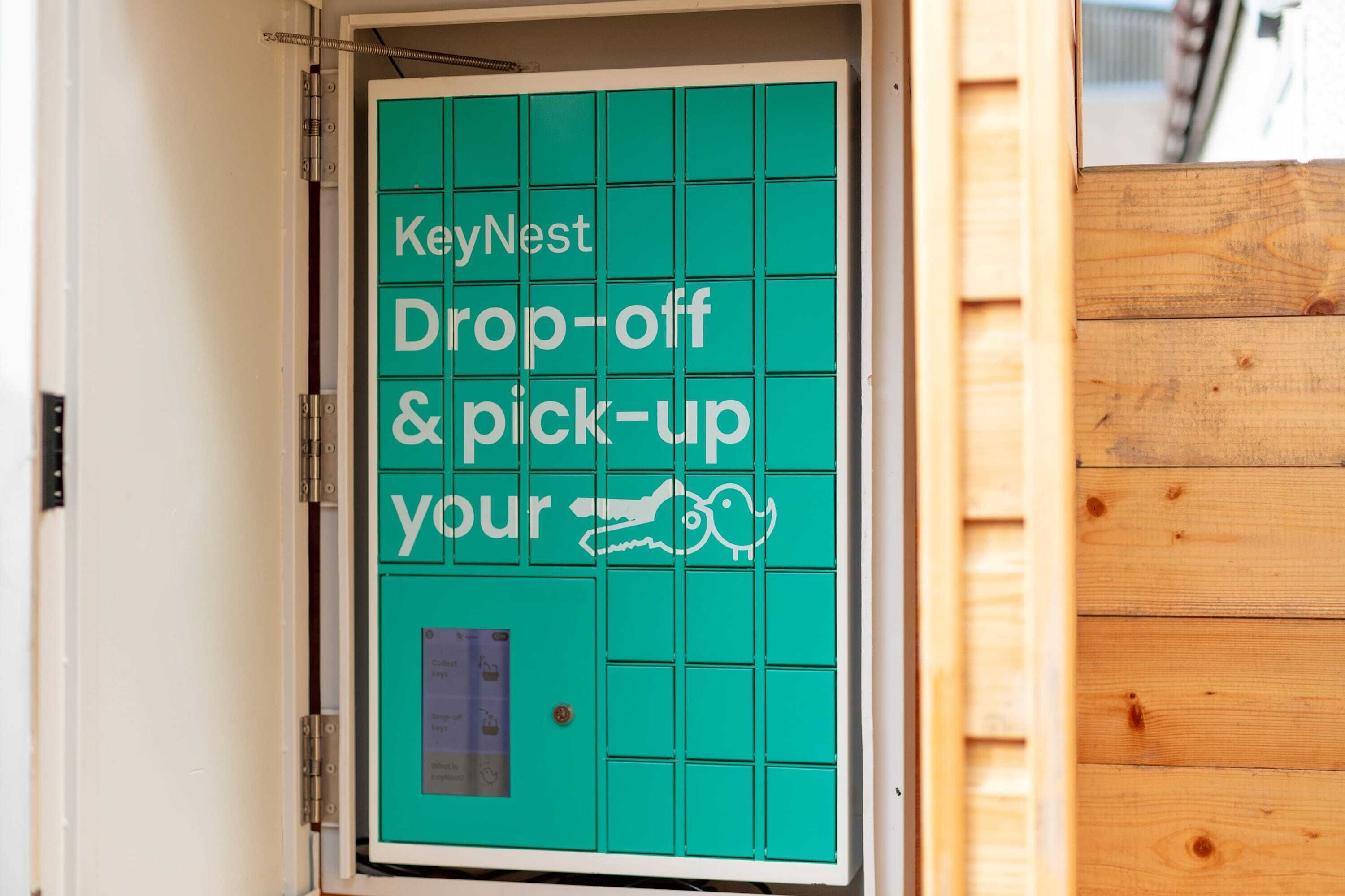 Een KeyNest deur voor sleuteloverdracht en -ophaling, met een rasterpatroon en een klein raampje.