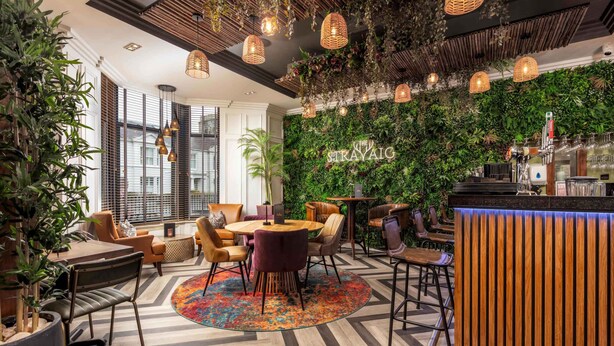 A cozy lounge area with a round table, chairs, and a vibrant rug. - The Kylestrome - Suite (Ayr)