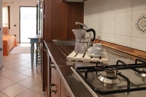 Eine Küche mit Gaskochfeld, Kaffeemaschine und Spüle.