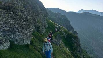 Un sendero de montaña estrecho con excursionistas.