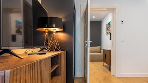 A modern living room with a wooden entertainment unit, a floor lamp, and a sofa. - Pensiunea Casa Weiss (Rimetea)
