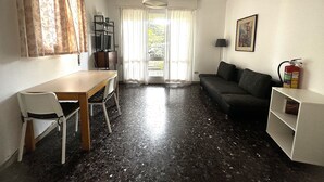 Kompakti oleskelutila, jossa on ruokailualue, sohva ja televisio.