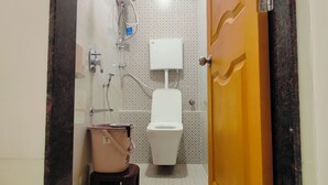 Une petite salle de bain avec des toilettes, un lavabo et une douche.
