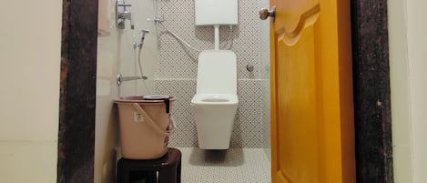 Une petite salle de bain avec des toilettes, un lavabo et une douche.