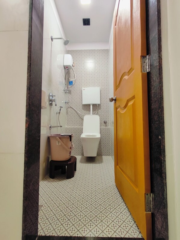 A small bathroom with a toilet, a sink, and a shower. - HOTEL M R STAY (Mumbai)