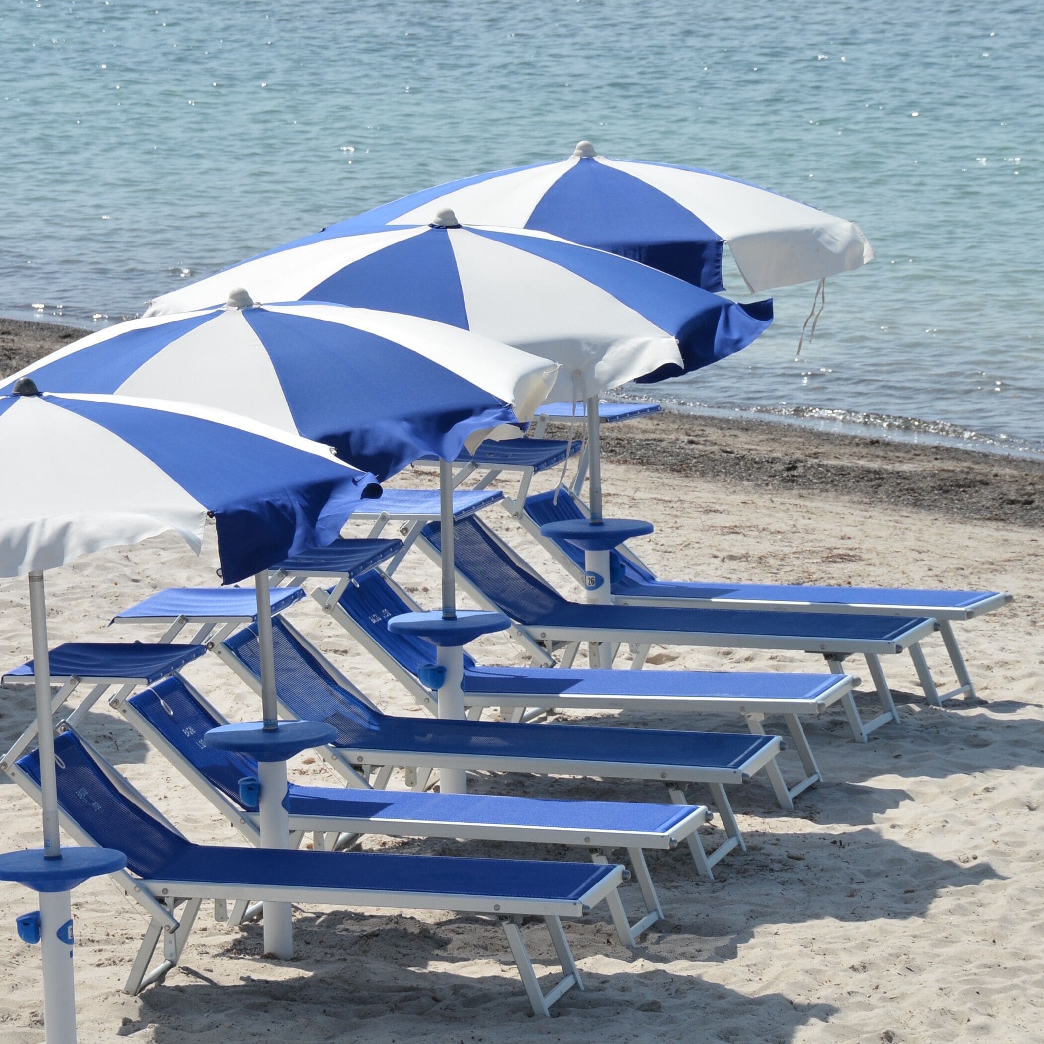 Privatstrand, weißer Sandstrand, Liegestühle, Sonnenschirme