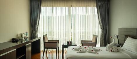 A hotel room with two beds, a desk, and a chair.