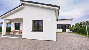 A modern two-story house with a covered patio and a paved driveway. - Holliday villa (Valias)