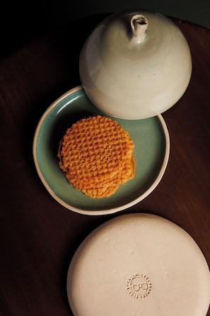 A plate with a waffle, a teapot, and a lid on a table. - Babel Lille (Lille)