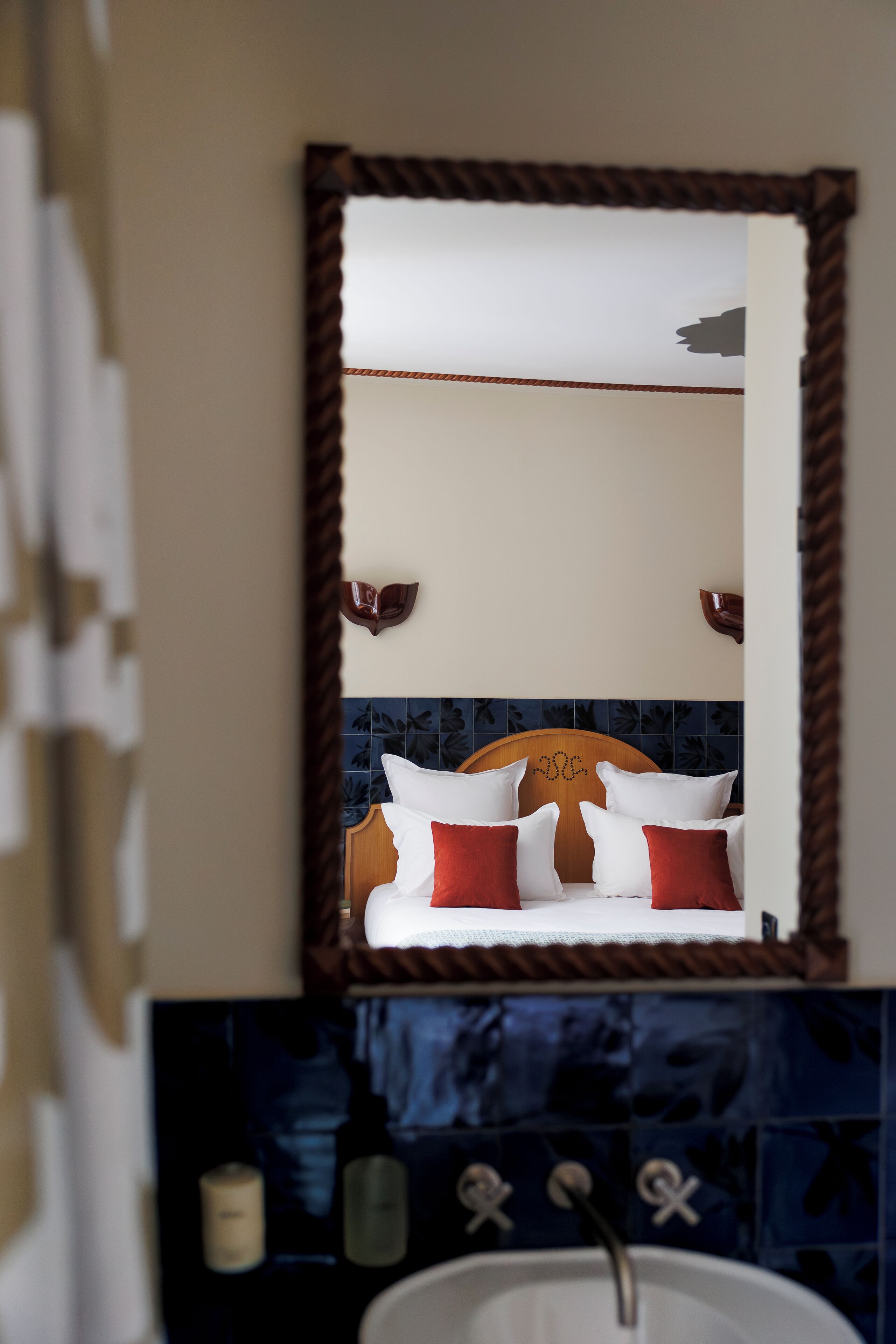 A bathroom with a wooden headboard, a mirror, and a sink.