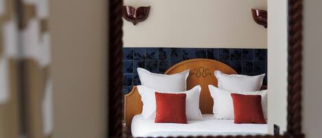 A bathroom with a wooden headboard, a mirror, and a sink.