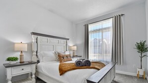 A neatly arranged bedroom with a large bed, two bedside tables, and a window with curtains. - Heber Valley Escape w/ Games, Theater & Hot Tub (Heber City)