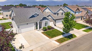 A residential neighborhood with houses featuring gabled roofs, front yards, and a clear view of distant mountains. - Heber Valley Escape w/ Games, Theater & Hot Tub (Heber City)