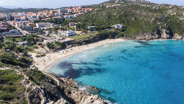 Une ville côtière dotée d’une plage, de falaises rocheuses et d’immeubles d’habitation.