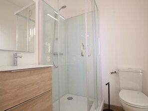 A modern bathroom with a glass-enclosed shower, a wooden vanity, and a white toilet. - Historic house in Normandy with panoramic views (Belval)