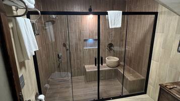 Un baño moderno con ducha envuelta en vidrio, inodoro y lavamanos.