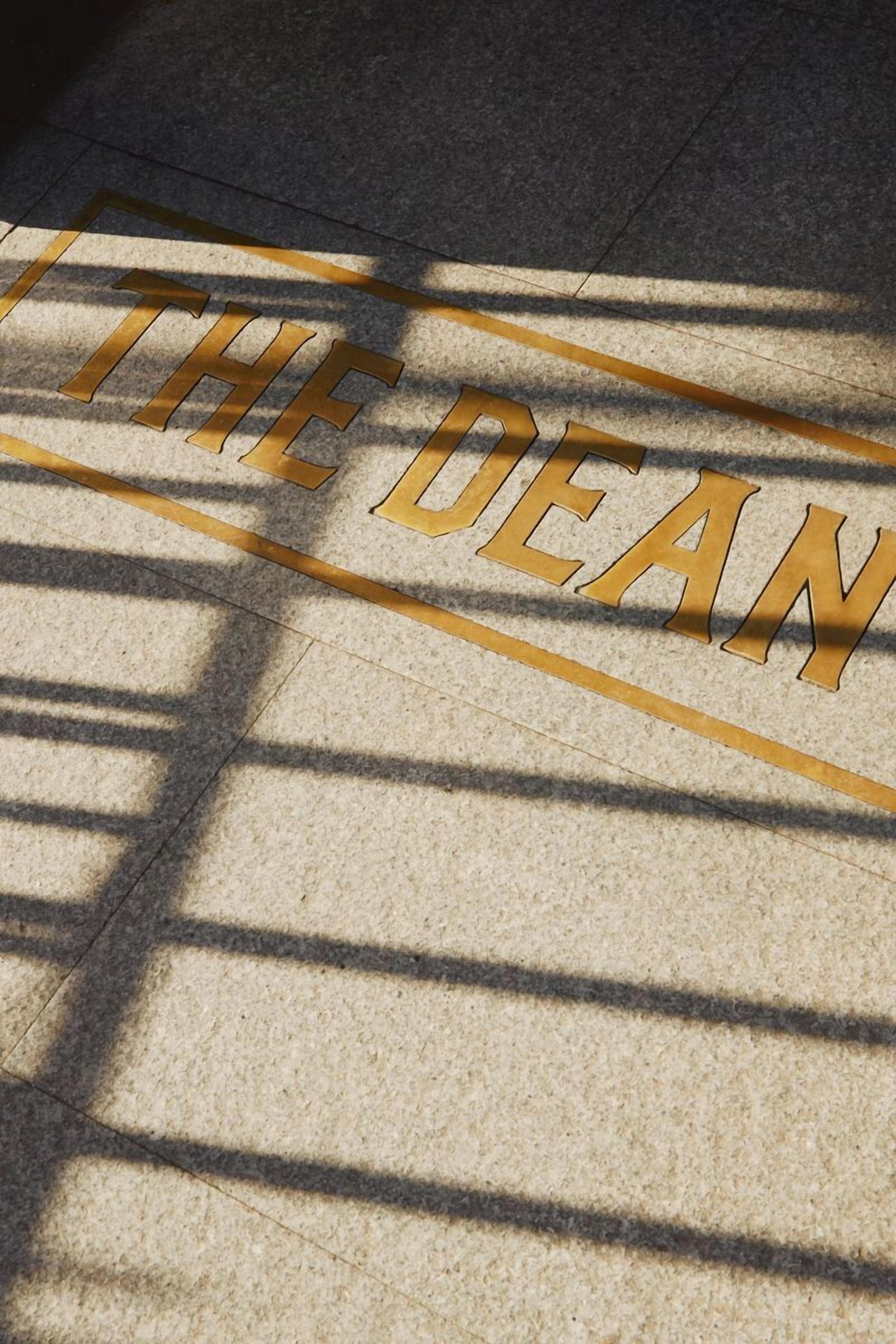A stone floor with the words "THE DEAN" engraved in gold lettering.