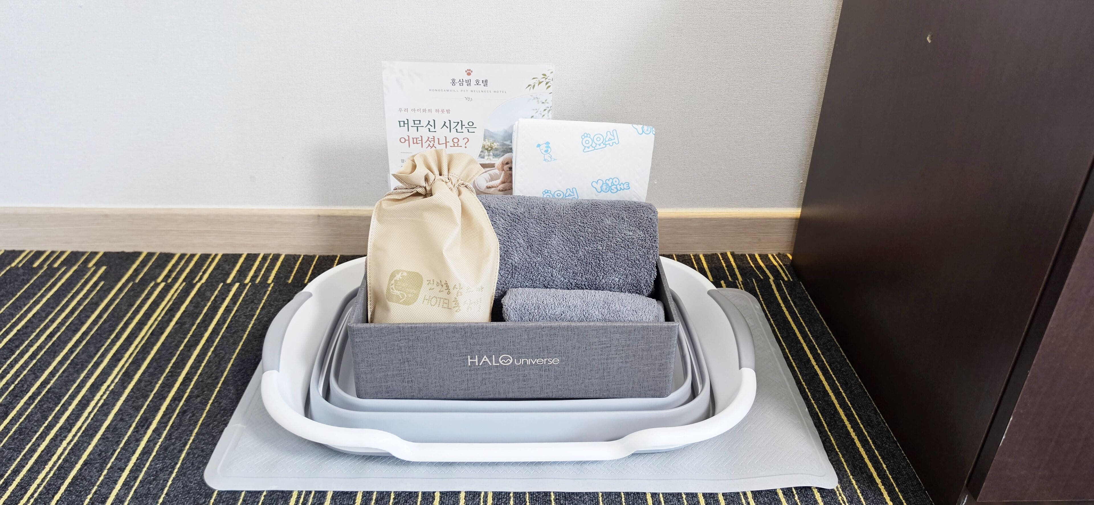 A hotel room with a bed, a bedside table, a wall-mounted TV, and a window.