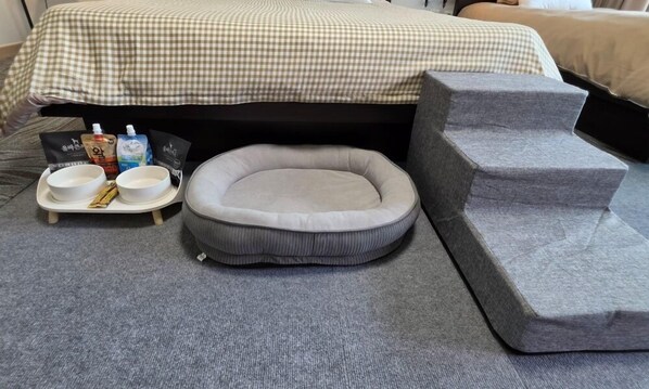 A pet bed, a tray with bowls and snacks, and a set of steps leading to a bed. - Jinan redginseng Ville (Jinan)
