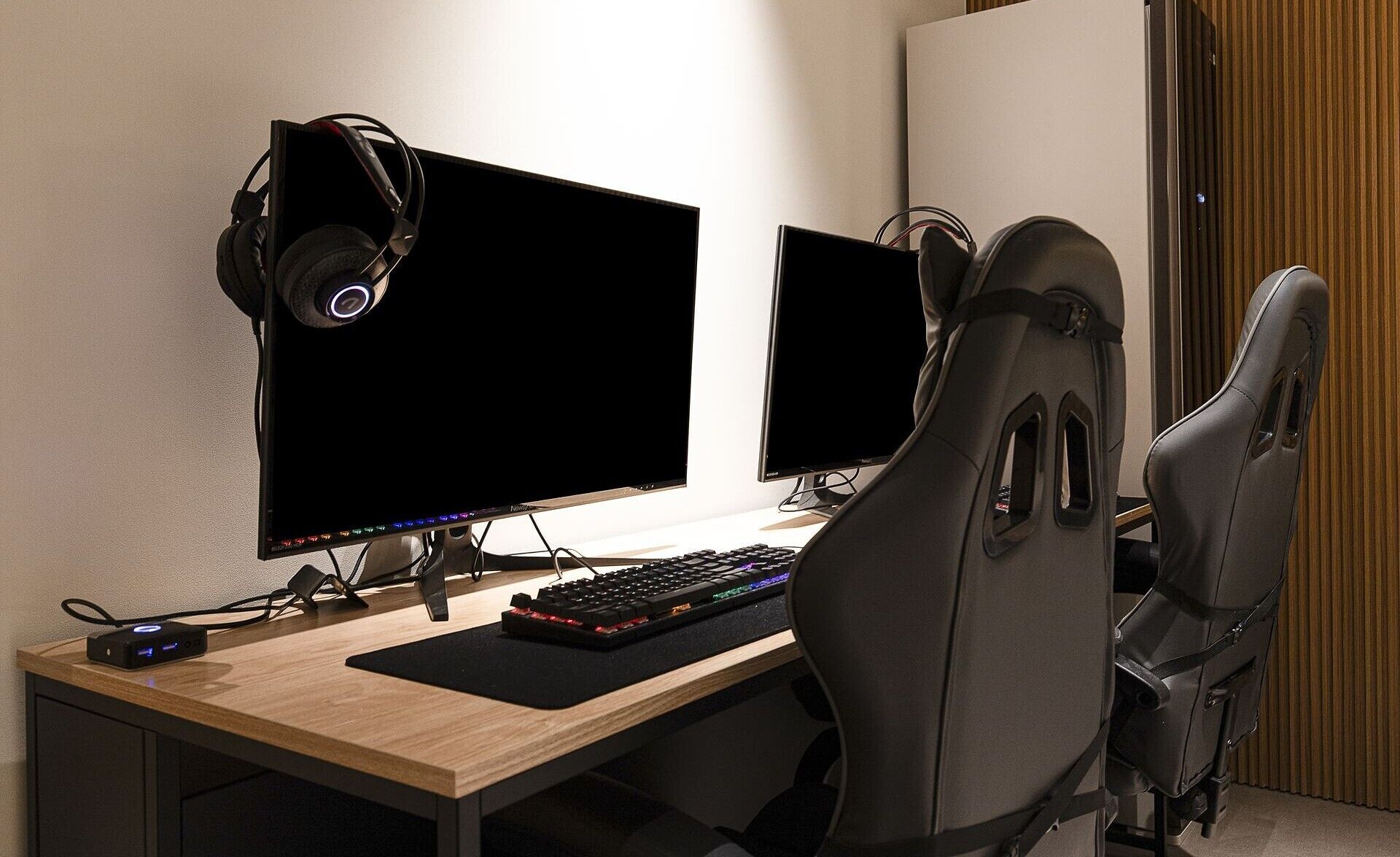 A gaming setup with two monitors, a keyboard, a mouse, and a headset.